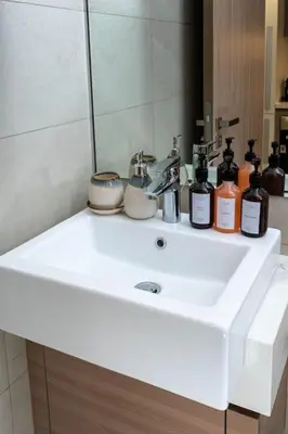 a bathroom sink with a mirror and bottles on it at Nasma Luxury Stays - Dreamy Getaway Unwind in a Modern Dubai Studio in Dubai