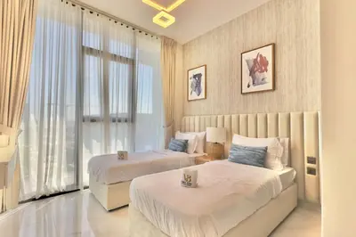 a bedroom with two beds and a large window at Relaxing 2BR Escape with Private Pool Samana GA by Vibel in Dubai