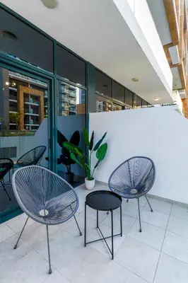 two chairs and a table in a building at Nasma Luxury Stays - Cozy Urban Studio at Azizi Riviera 43 in Meydan in Dubai