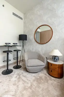 a living room with a chair and a mirror at Nasma Luxury Stays - Cozy Urban Studio at Azizi Riviera 43 in Meydan in Dubai
