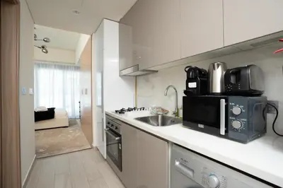 a kitchen with a sink and a microwave at Nasma Luxury Stays - Cozy Urban Studio at Azizi Riviera 43 in Meydan in Dubai