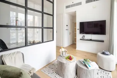 a living room with white walls and a large window at Frank Porter - DEC Tower 3 in Dubai