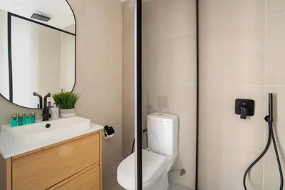 a bathroom with a toilet and a sink and a mirror at Frank Porter - DEC Tower 3 in Dubai