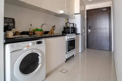 a kitchen with a washing machine and a refrigerator at Frank Porter - Damac Ghalia Tower - Studio in Dubai