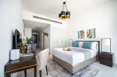 a bedroom with a desk and a bed and a desk and a computer at Frank Porter - Damac Ghalia Tower - Studio in Dubai