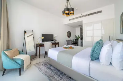 a bedroom with a bed and a chair and a desk at Frank Porter - Damac Ghalia Tower - Studio in Dubai