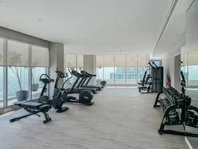 a gym with treadmills and ellipticals in a building at Luxurious Studio Marina View Condor Marina Star in Dubai