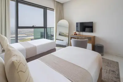 a hotel room with two beds and a television at Frank Porter - The One JBR in Dubai