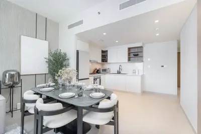a kitchen and dining room with a table and chairs at Downtown Views Open Burj View 34th Floor 2BD in Dubai