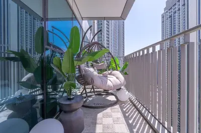a balcony with chairs and potted plants on a building at Downtown Views Open Burj View 34th Floor 2BD in Dubai