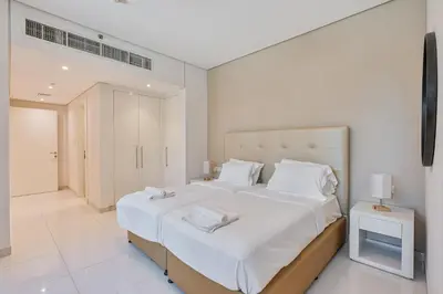 a bedroom with a large bed with white sheets and pillows at 3BR Apartment in Business Bay with Pool & Canal Walk in Dubai