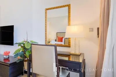 a mirror on a wall next to a desk with a lamp at LUX The JW Marina Studio 3 in Dubai