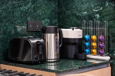 a coffeemaker and a coffee maker on a counter at Pool side view at Dubai Creek Harbour by DuStay in Dubai