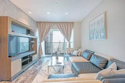 a living room with a couch and a television at FIRST CLASS 1BR Amazing Marina Views in Dubai