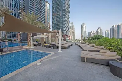 a hotel with a pool and a row of beds at FIRST CLASS 1BR Amazing Marina Views in Dubai