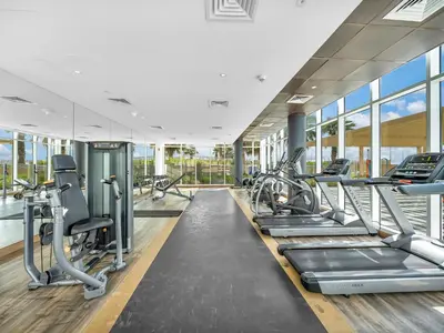 a gym with treadmills and elliptical machines at Dar Mama - Cozy modern apartment in Golf Vita, Dubai in Dubai