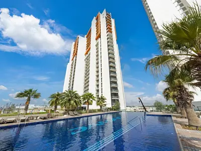 a hotel with a swimming pool and palm trees at Dar Mama - Cozy modern apartment in Golf Vita, Dubai in Dubai