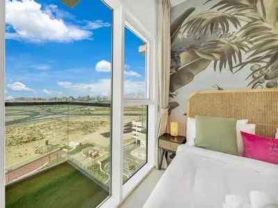 a bedroom with a window with a view of a beach at Dar Mama - Cozy modern apartment in Golf Vita, Dubai in Dubai