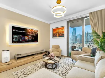 a living room with a couch and a tv at New! PS5! Burj Khalifa view & Infinity Pool in Dubai