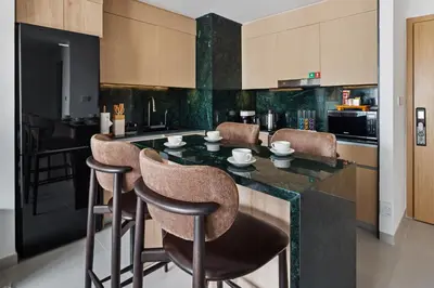 a kitchen with a black counter with bar stools at Spacious Apartment - Dubai Creek Harbour by DuStay in Dubai