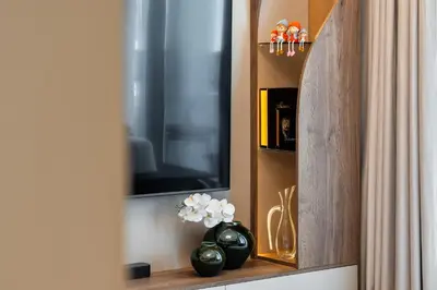 a cabinet with a television and vases on a shelf at Modern Apartment in Dubai Creek Harbour By DuStay in Dubai
