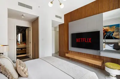 a bedroom with a bed and a television on a wall at Modern Apartment in Dubai Creek Harbour By DuStay in Dubai