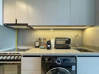 a kitchen with a washing machine and a sink at Chic and Bright Studio in Meydan in Dubai