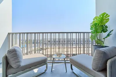 a room with two chairs and a balcony with a view at Chic and Bright Studio in Meydan in Dubai