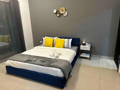 a bedroom with a large bed with yellow and blue at Himalaya Holiday Homes 1BHK - Dubai Marina in Dubai