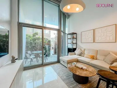 a living room with a couch and a table at Modern studio in villa Pera tower JVC in Dubai