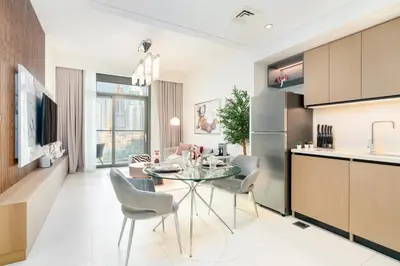 a kitchen and living room with a glass table and chairs at Iconic 1BR l Boulevard View l Walk to Dubai Mall in Dubai