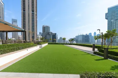 a green lawn in the middle of a city at Iconic 1BR l Boulevard View l Walk to Dubai Mall in Dubai