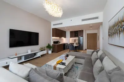 a living room with a couch and a flat screen tv at La Cote, Port de La Mer, Jumeirah 1 - Mint Stay in Dubai