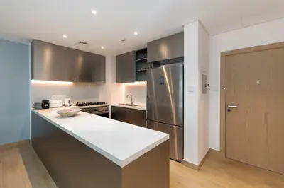 a kitchen with a white counter top and a refrigerator at La Cote, Port de La Mer, Jumeirah 1 - Mint Stay in Dubai