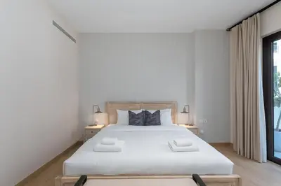 a white bedroom with a large bed with two lamps at La Cote, Port de La Mer, Jumeirah 1 - Mint Stay in Dubai