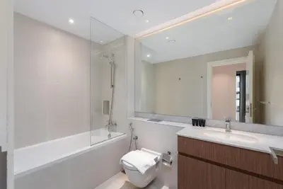 a bathroom with a toilet and a sink and a mirror at La Cote, Port de La Mer, Jumeirah 1 - Mint Stay in Dubai