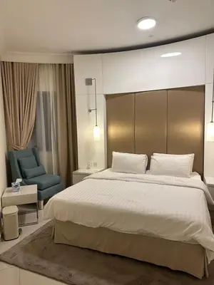 a bedroom with a large bed and a blue chair at Royal Apartments Dubai Mall in Dubai