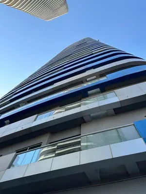 a tall building with glass windows against a blue sky at Royal Apartments Dubai Mall in Dubai