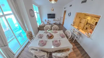 a dining room with a white table and chairs at Elegant 2 Bedroom Apartment in Dubai Marina- Just 1 Min walk from JBR Beach in Dubai