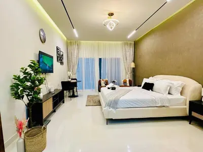 a bedroom with a large bed and a living room at Cozy Hideaway-Damac Cour Jardin near Dubai Mall in Dubai