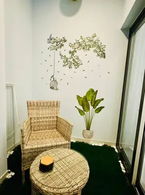 a room with a chair and a table and a plant at Cozy Hideaway-Damac Cour Jardin near Dubai Mall in Dubai