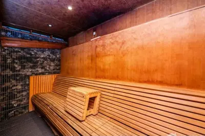 a wooden bench in a sauna with a small stool at Cozy Hideaway-Damac Cour Jardin near Dubai Mall in Dubai
