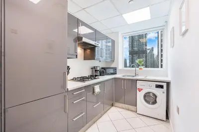 a kitchen with a washing machine and a window at Beautiful Home at the Heart of Marina in Dubai