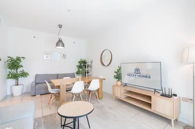 a living room with a table and a tv at Beautiful Home at the Heart of Marina in Dubai