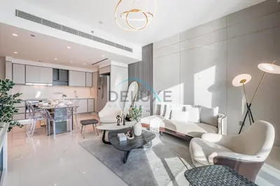a living room with white furniture and a kitchen at Classy 3BR with Assistant Room at Sunrise Bay Tower 1 Emaar Beachfront, Dubai Marina by Deluxe Holiday Homes in Dubai