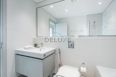 a white bathroom with a sink and a mirror at Classy 3BR with Assistant Room at Sunrise Bay Tower 1 Emaar Beachfront, Dubai Marina by Deluxe Holiday Homes in Dubai