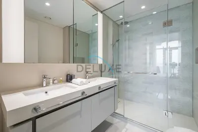 a bathroom with a white sink and a shower at Classy 3BR with Assistant Room at Sunrise Bay Tower 1 Emaar Beachfront, Dubai Marina by Deluxe Holiday Homes in Dubai