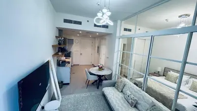 a living room with a couch and a table at Studio Hotel Apartment Brand New Azizi Riv 14 in Dubai