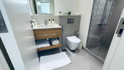 a bathroom with a sink and a toilet and a shower at Studio Hotel Apartment Brand New Azizi Riv 14 in Dubai