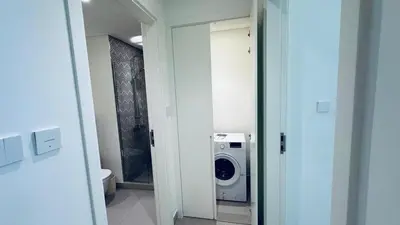 a bathroom with a washing machine and a washer and dryer at Studio Hotel Apartment Brand New Azizi Riv 14 in Dubai